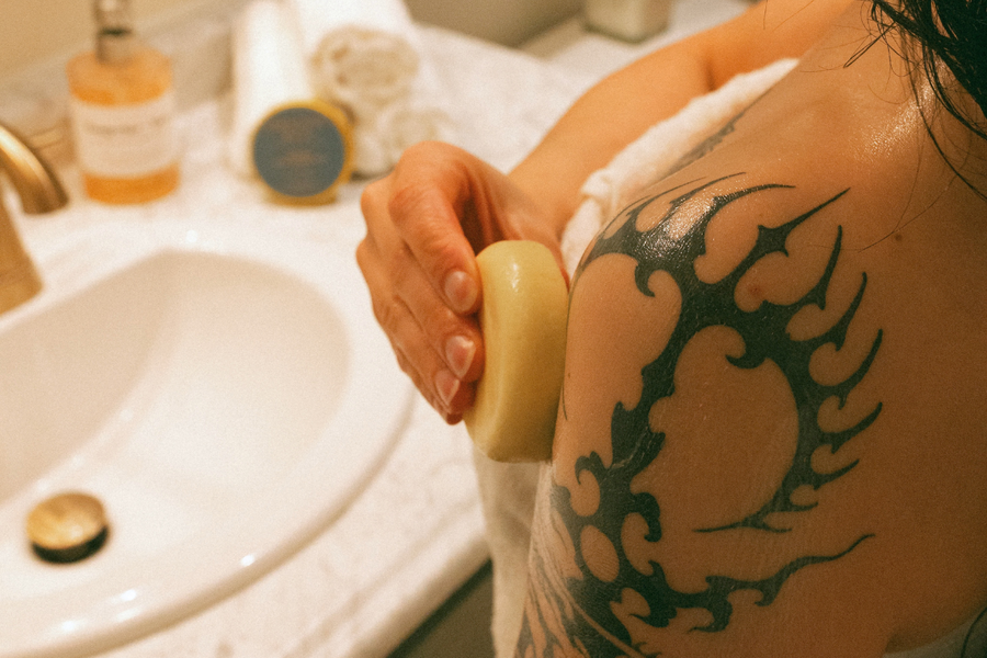 Nourish Body Lotion Bar being applied to shoulder for dry winter skin
